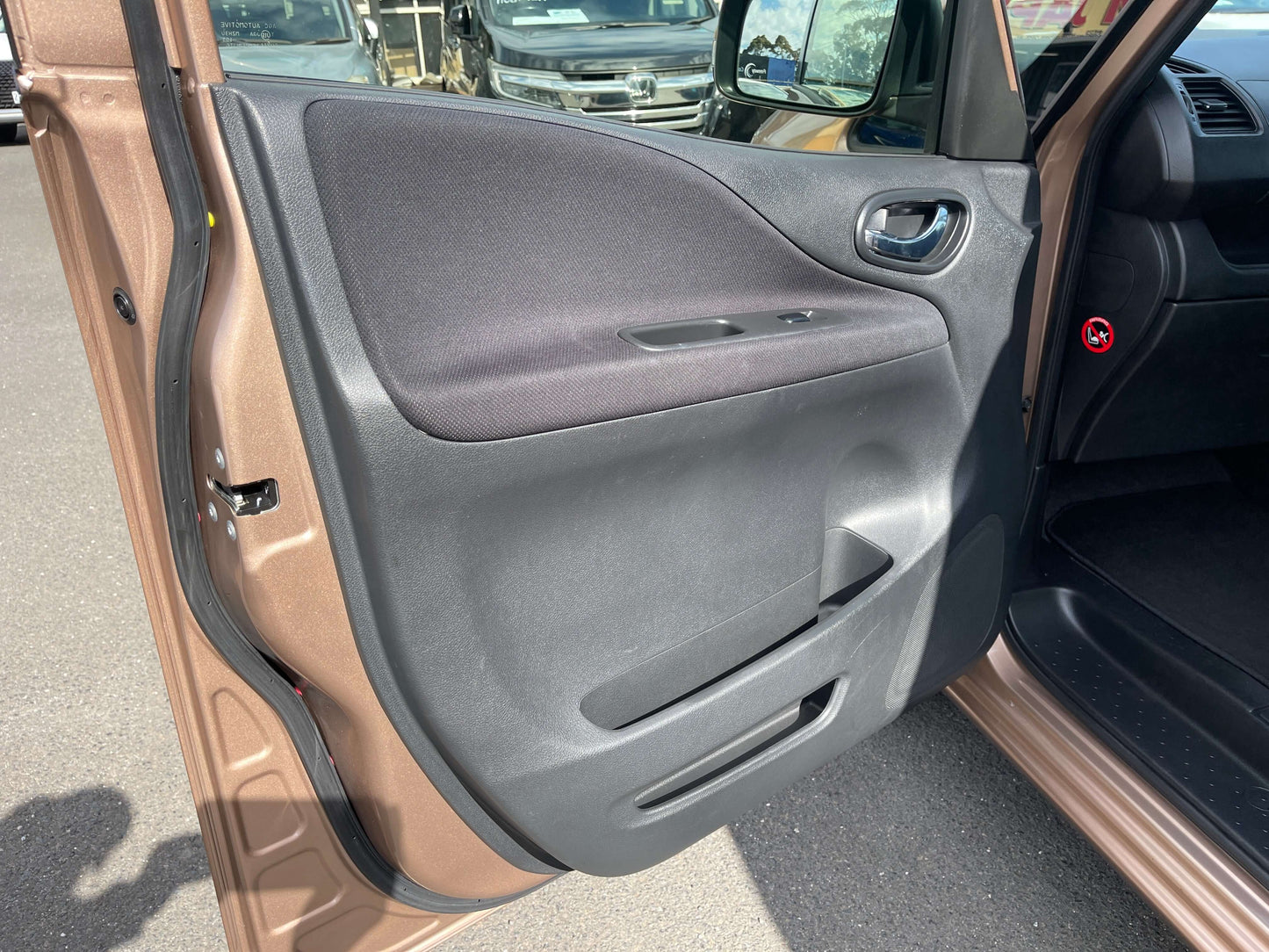 Interior view of the driver's side door of a 2016 Nissan Serena showing design and materials.