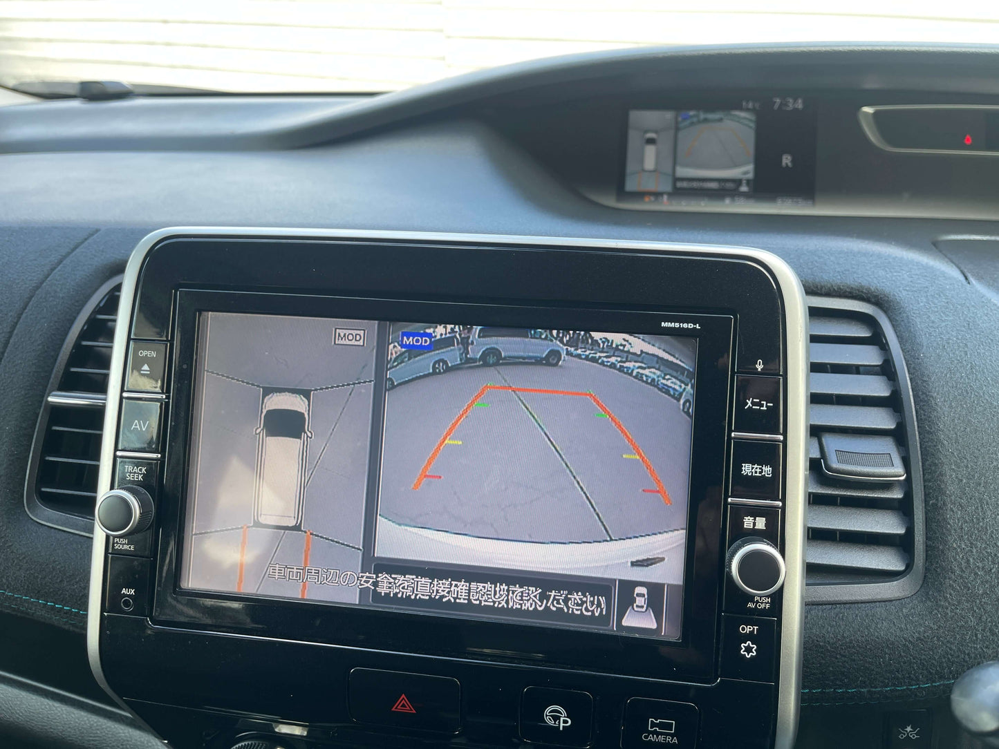 Interior view of 2016 Nissan Serena dashboard with rearview camera display and parking assist features.