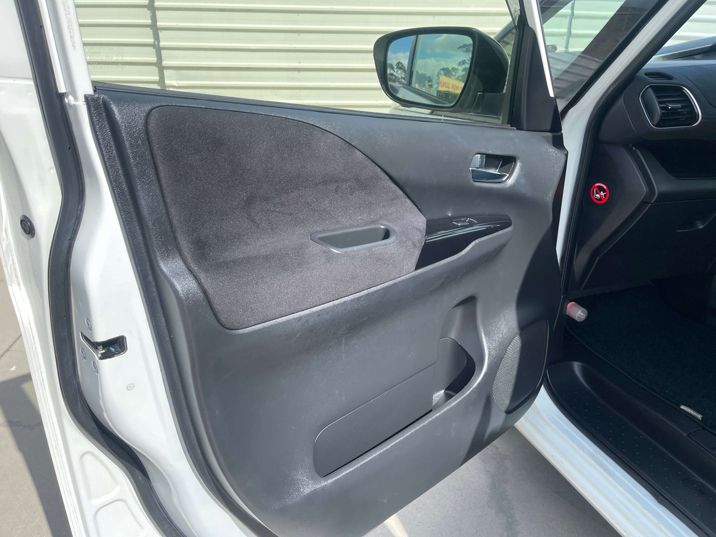 Interior view of the door panel of a 2016 Nissan Serena, showcasing sleek design and features.