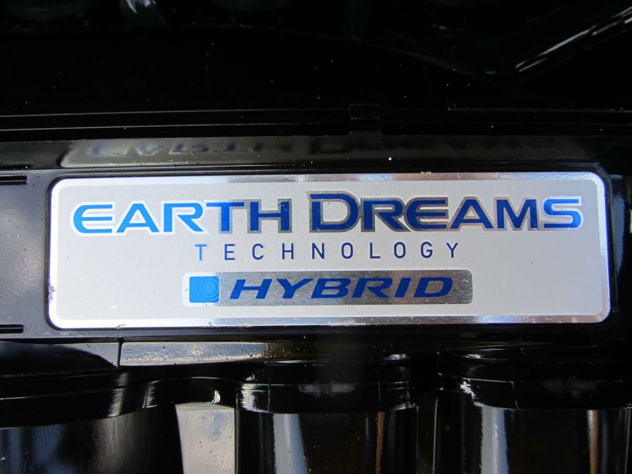Close-up of Earth Dreams Technology Hybrid badge on the engine of a 2017 Honda Fit 1.5L Hybrid.