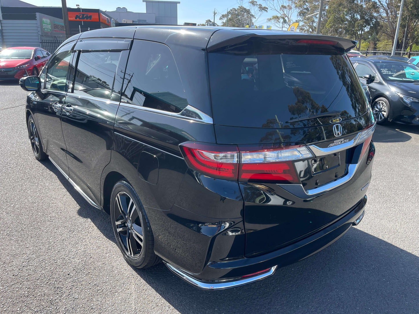 2016 Honda Odyssey 2.0 Hybrid Absolute Honda Sensing black minivan rear view with sleek design and tinted windows