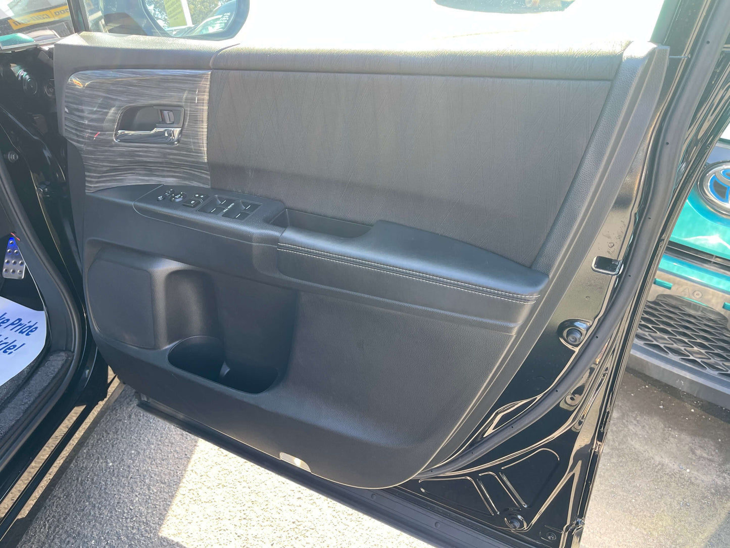 Interior view of 2016 Honda Odyssey 2.0 Hybrid door panel with control buttons and storage compartments.
