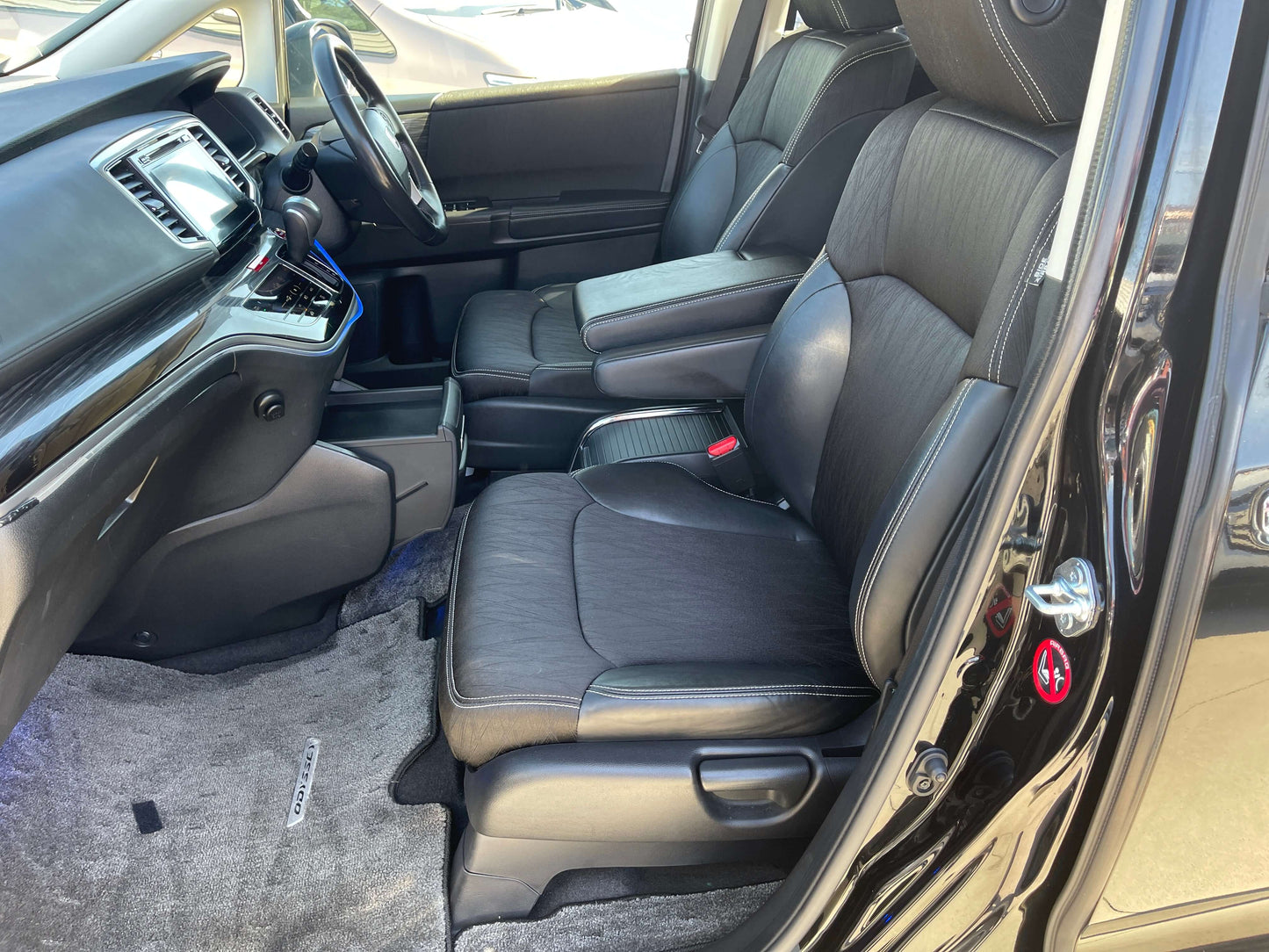 Interior view of a 2016 Honda Odyssey 2.0 Hybrid with leather seats and modern dashboard design.