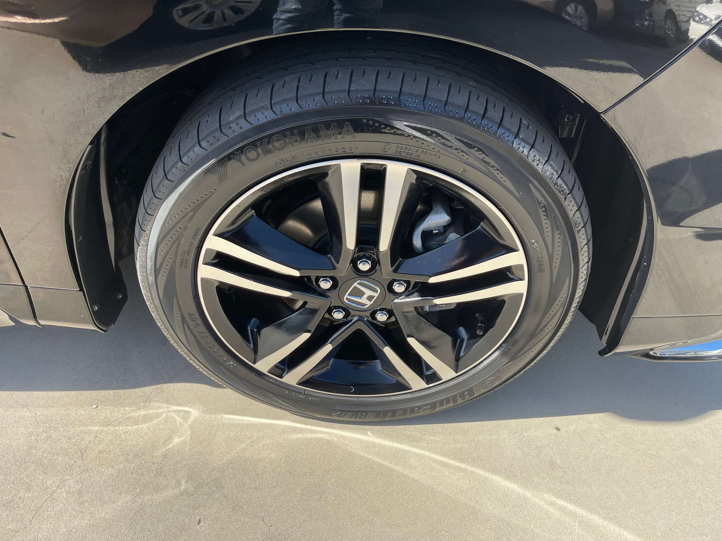 Wheel of a 2016 Honda Odyssey 2.0 Hybrid showing black alloy rims and tire.