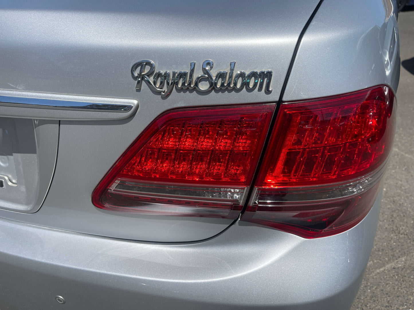 Close-up of the rear emblem and taillight of a 2008 Toyota Crown V6 3.0L Royal Saloon Luxury Sedan.