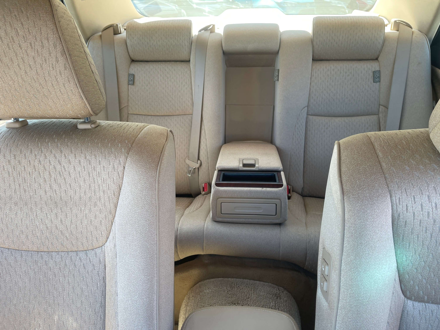 Interior view of the backseat of a 2008 Toyota Crown V6 3.0L Royal Saloon Luxury Sedan, featuring beige upholstery.