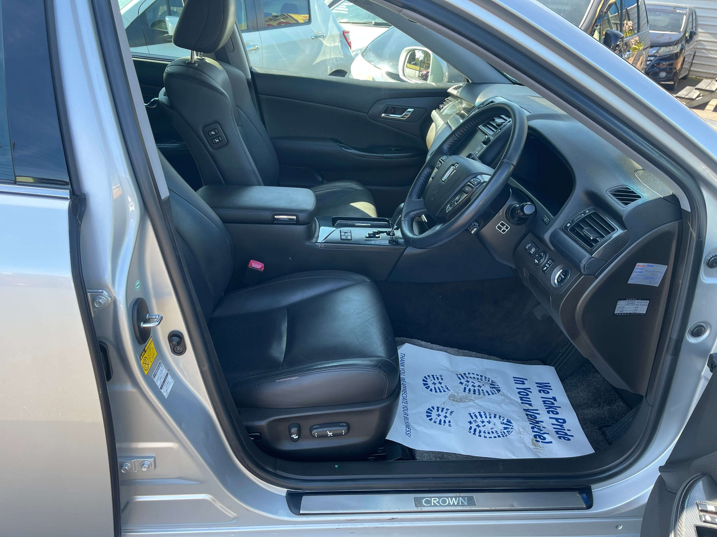 Interior view of the 2009 Toyota Crown V6 3.5L Hybrid luxury sedan showcasing black leather seats.