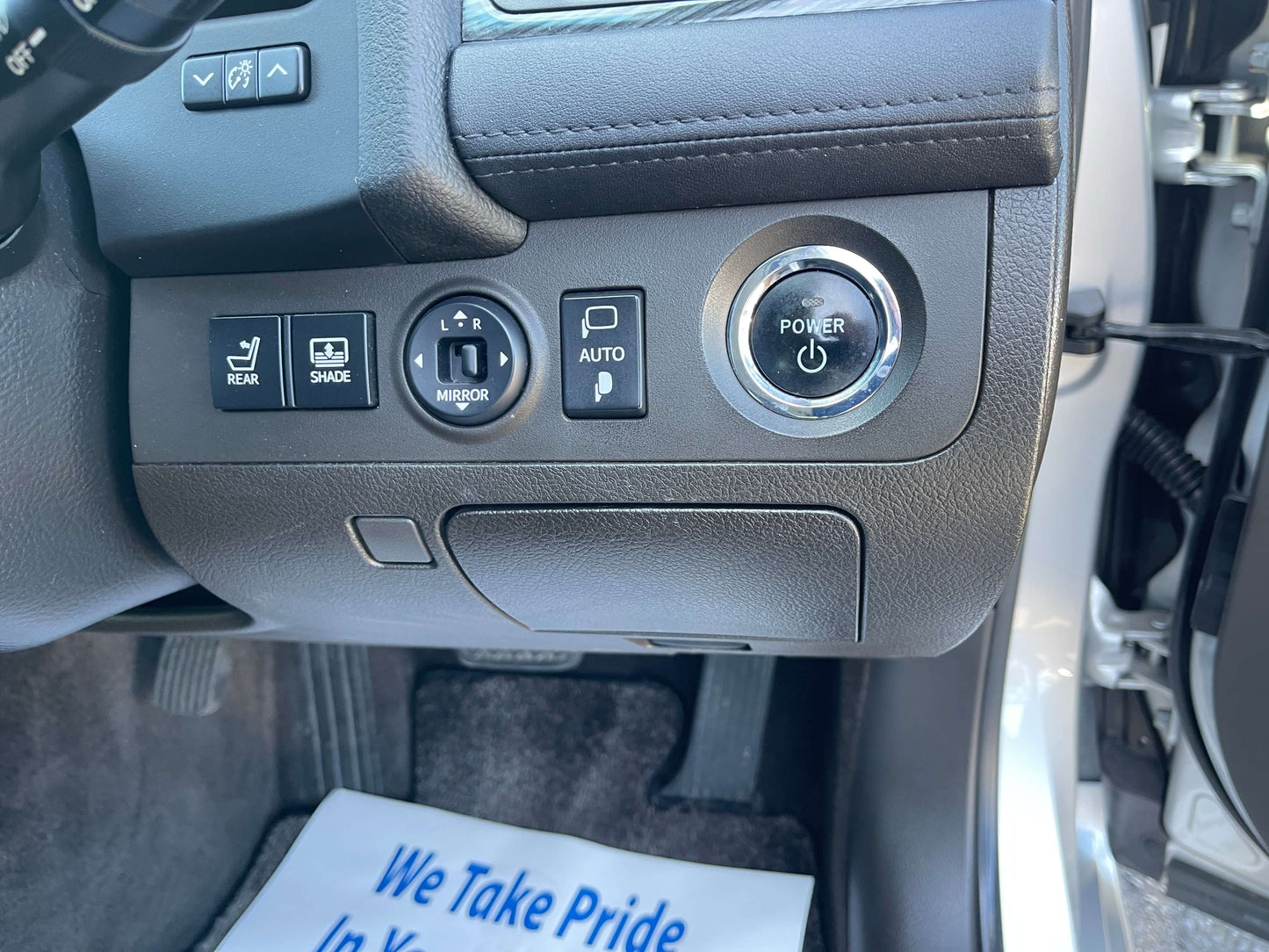 Interior controls of a 2009 Toyota Crown V6 3.5L Hybrid, featuring buttons for rear shade, auto, and power.