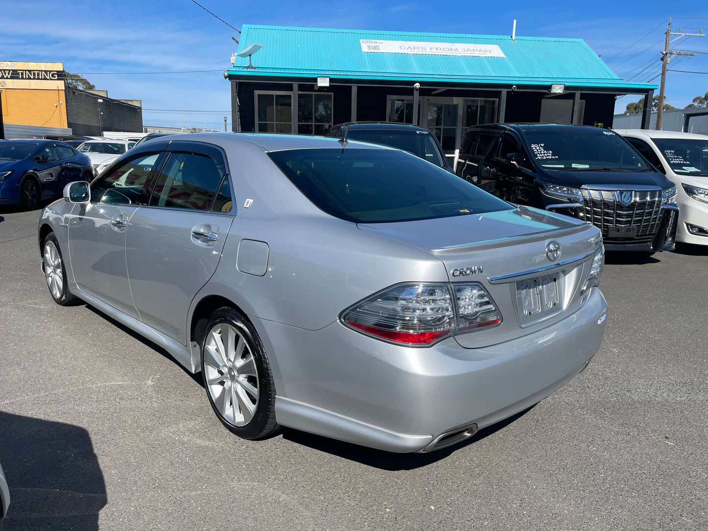 2009 Toyota Crown V6 3.5L Hybrid luxury sedan parked, showcasing sleek silver design and modern features.