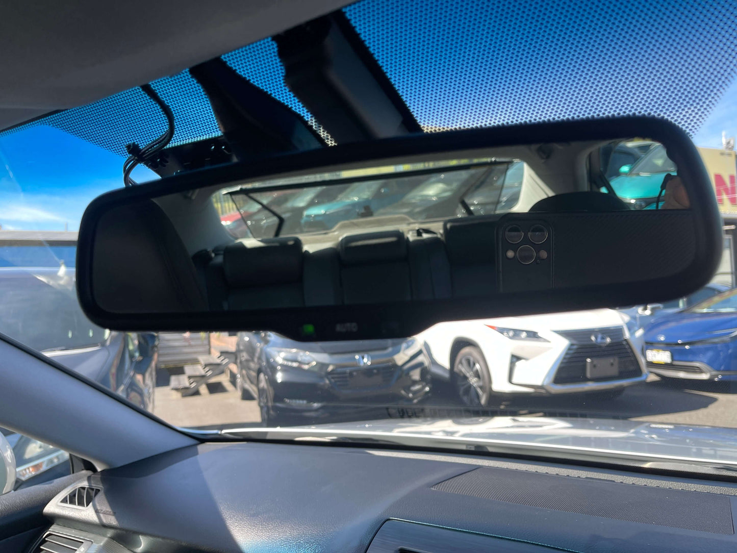 2009 Toyota Crown V6 3.5L Hybrid Rearview mirror in a car showing the interior and vehicles behind, featuring controls on the mirror.