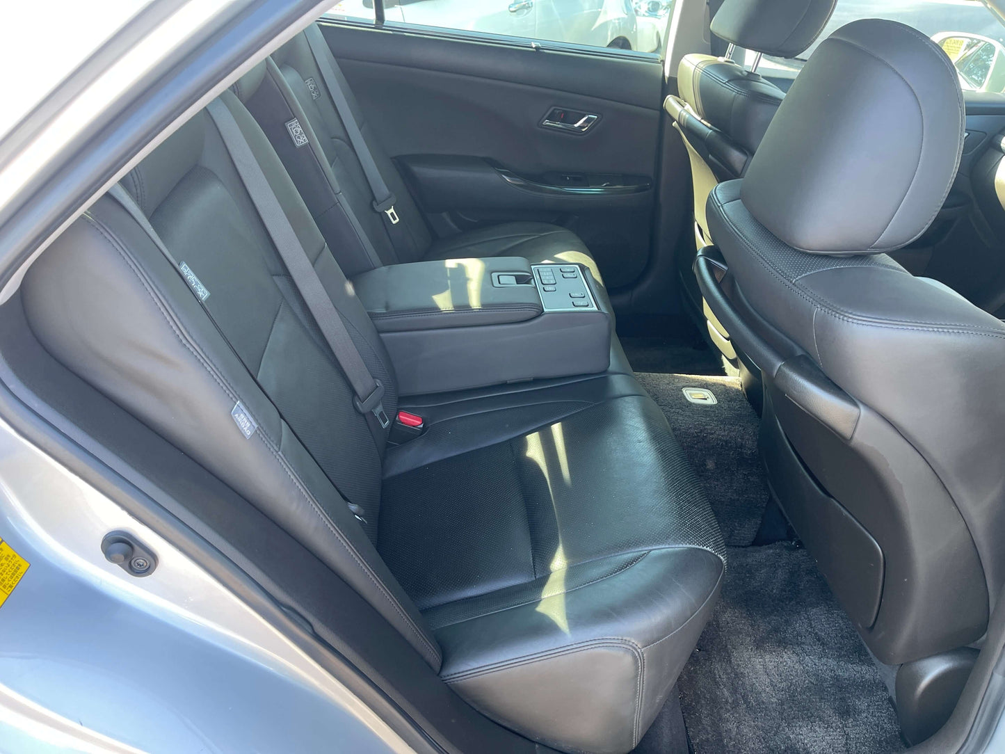 Interior view of the backseat of a 2009 Toyota Crown V6 3.5L Hybrid Luxury Sedan, showcasing leather seats and spacious cabin.
