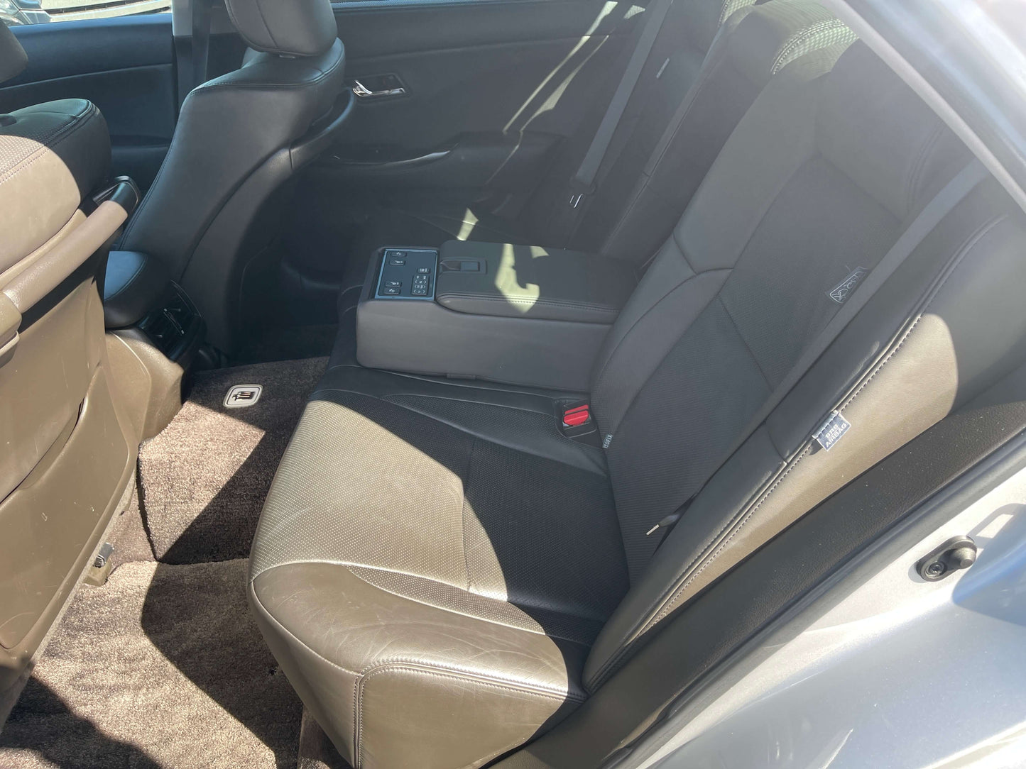 Interior view of the back seat of a 2009 Toyota Crown V6 3.5L Hybrid luxury sedan, showing comfortable seating and a central armrest.