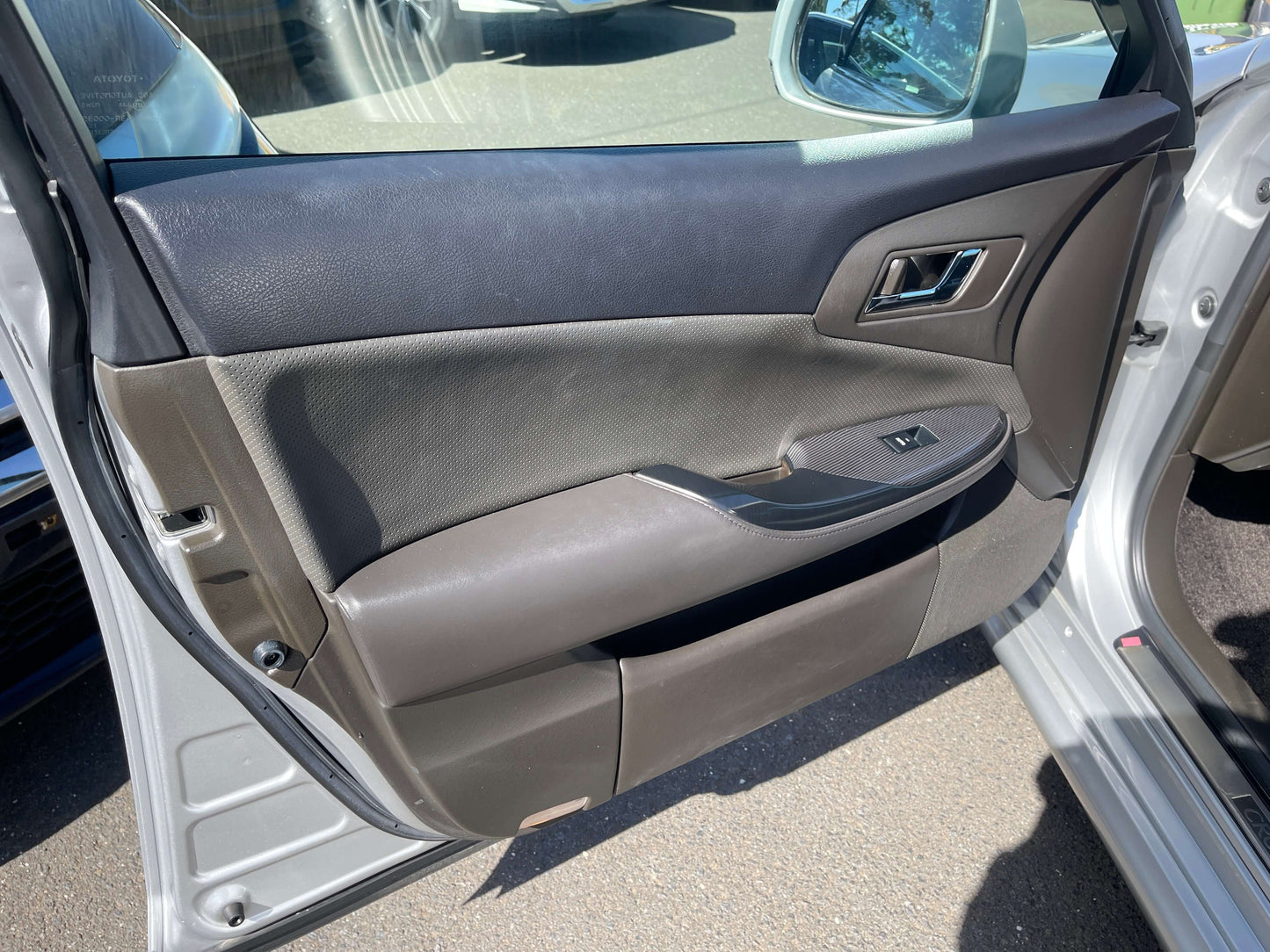Interior view of the door panel of a 2009 Toyota Crown V6 3.5L Hybrid Luxury Sedan, showcasing premium materials and design.