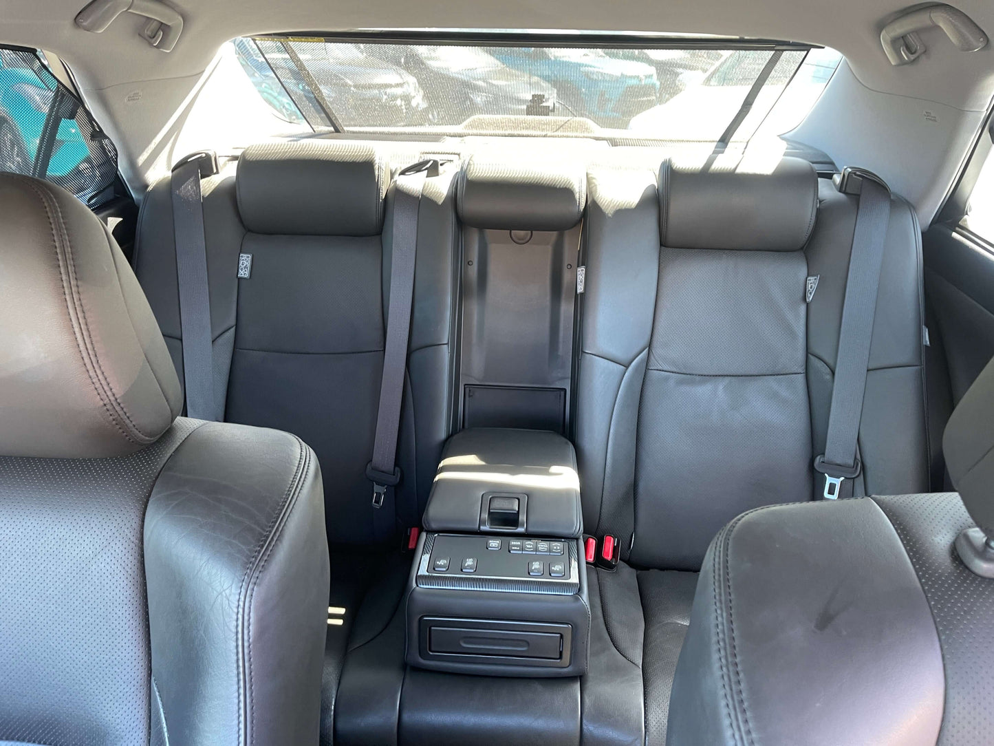 Interior view of the backseat in a 2009 Toyota Crown V6 3.5L Hybrid Luxury Sedan with black leather upholstery.