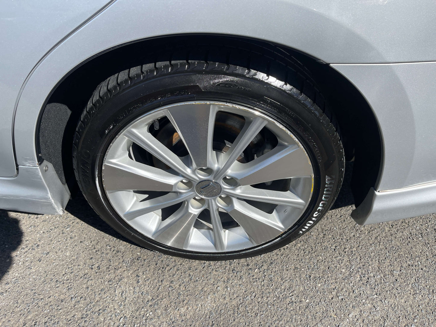 2009 Toyota Crown V6 3.5L Hybrid luxury sedan wheel close-up, showcasing alloy rim and tire tread.