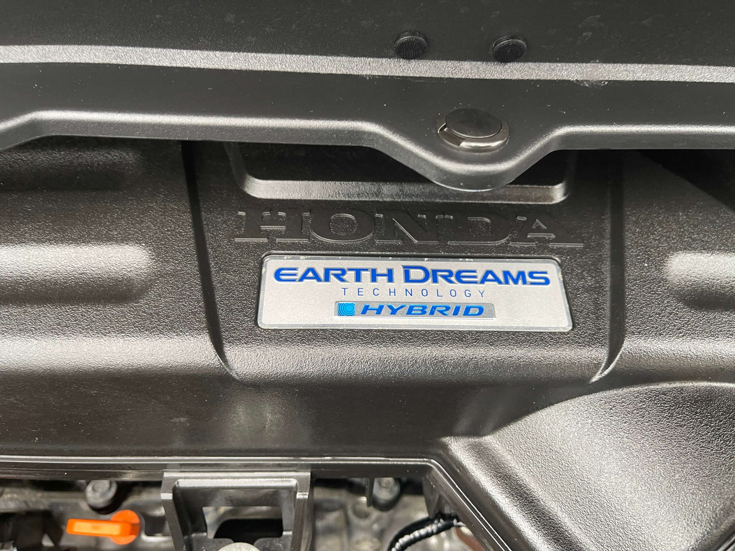 2018 Honda Honda Stepwgn 2.0 Spada Hybrid Close-up of the Honda Earth Dreams technology hybrid engine cover, showcasing advanced hybrid system branding.