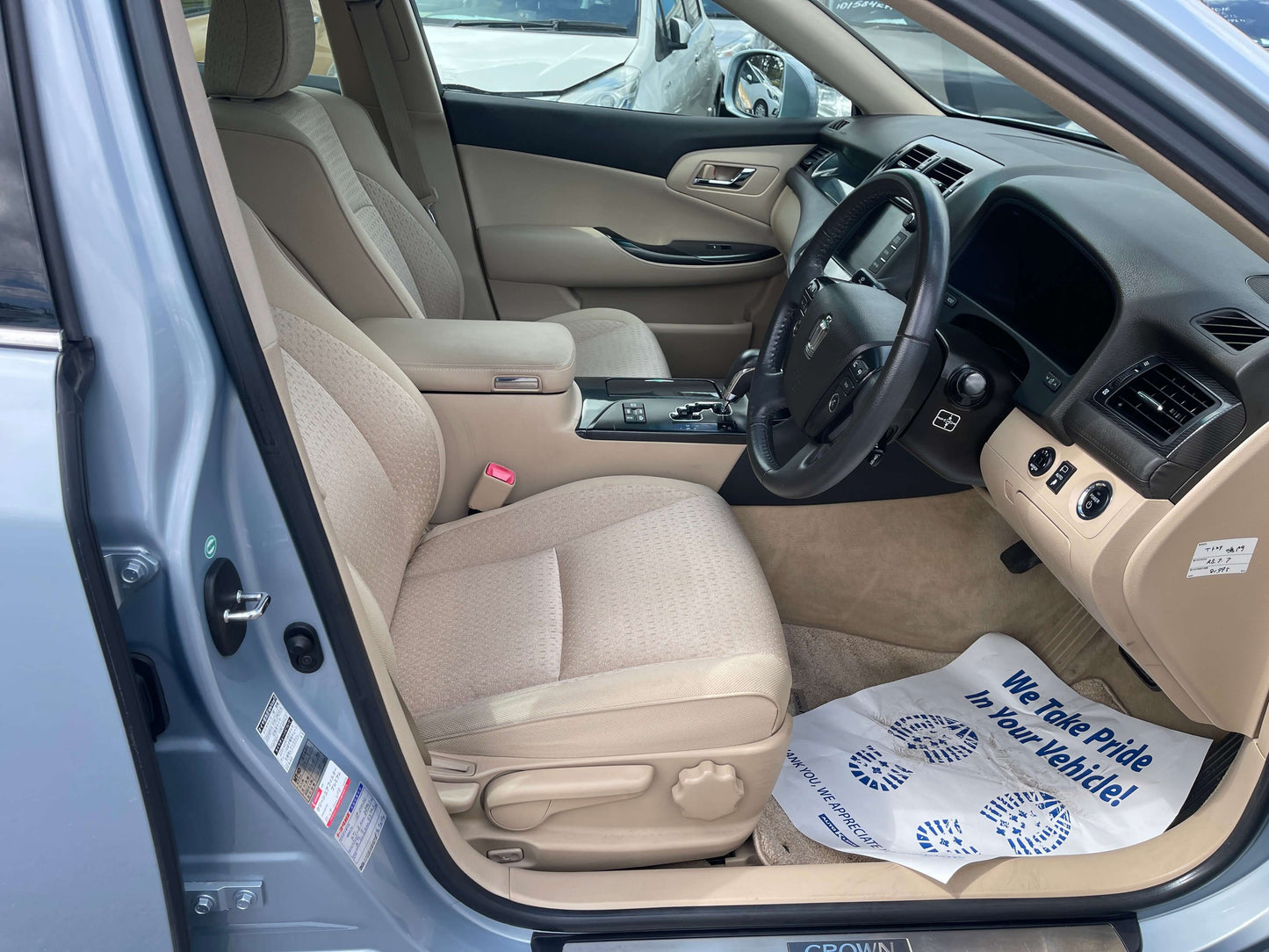 Interior view of a 2009 Toyota Crown V6 3.5L Hybrid Luxury Sedan showing dashboard and beige upholstery.