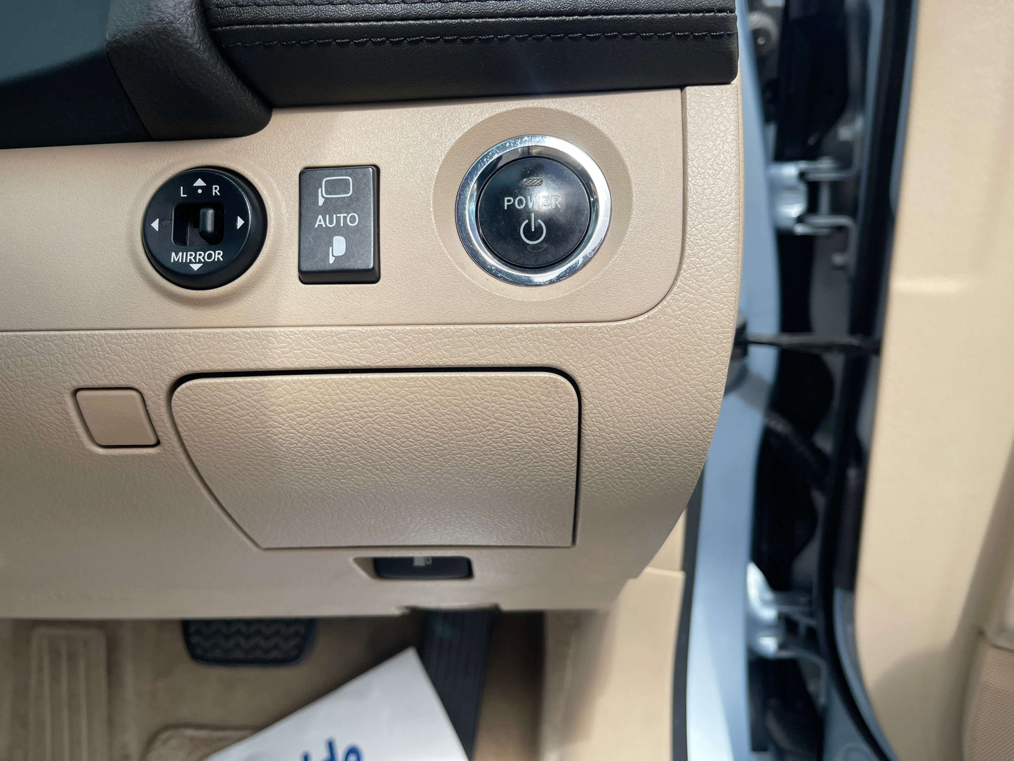 Interior control panel featuring auto mirror adjustment and power button in a 2009 Toyota Crown V6 3.5L Hybrid Luxury Sedan.