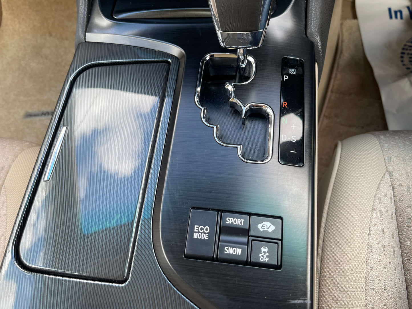 Interior console of a 2009 Toyota Crown V6 3.5L Hybrid Luxury Sedan with gear selector and drive mode buttons.
