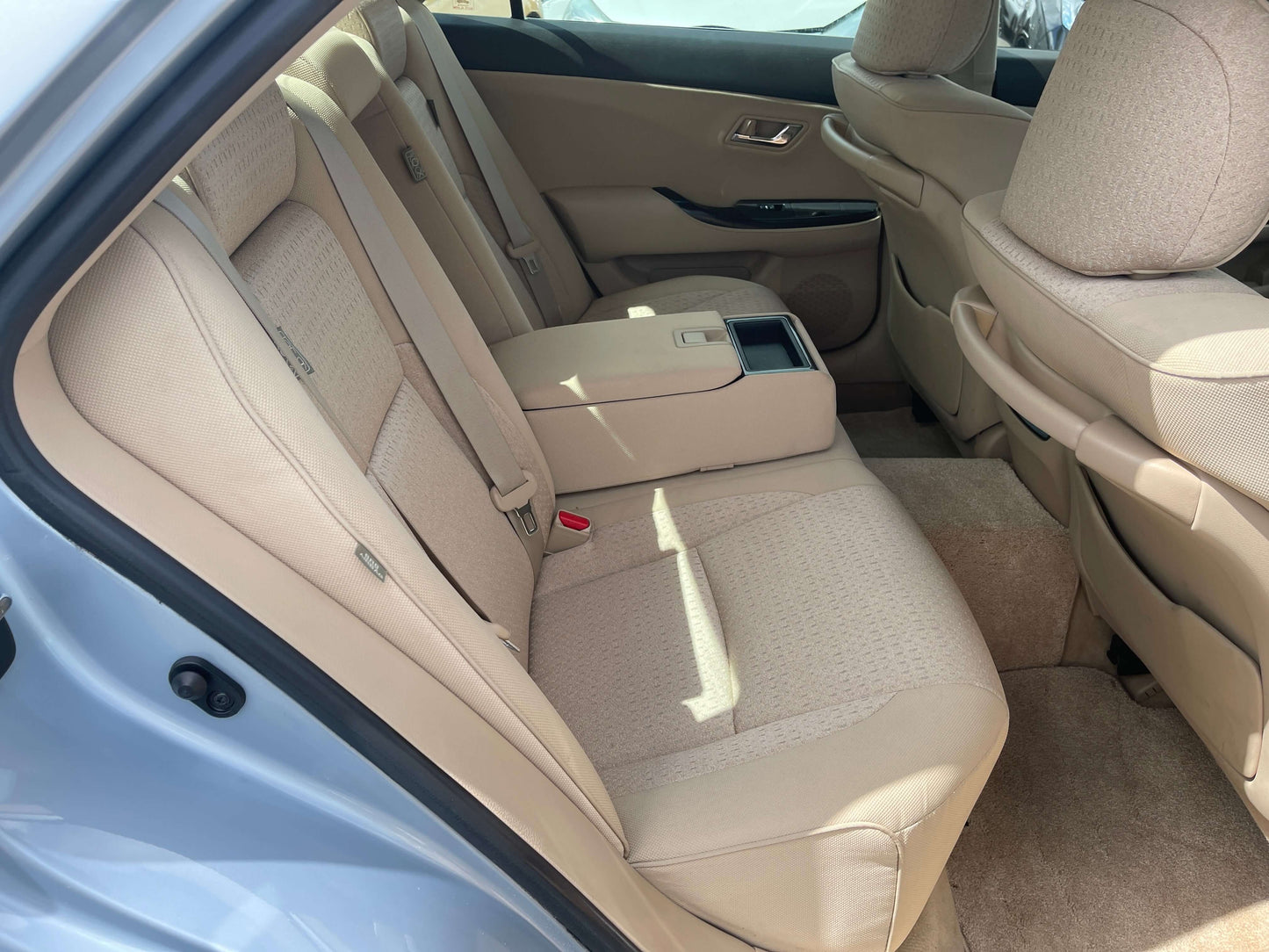 Interior view of the back seats of a 2009 Toyota Crown V6 3.5L Hybrid Luxury Sedan, showcasing beige upholstery.