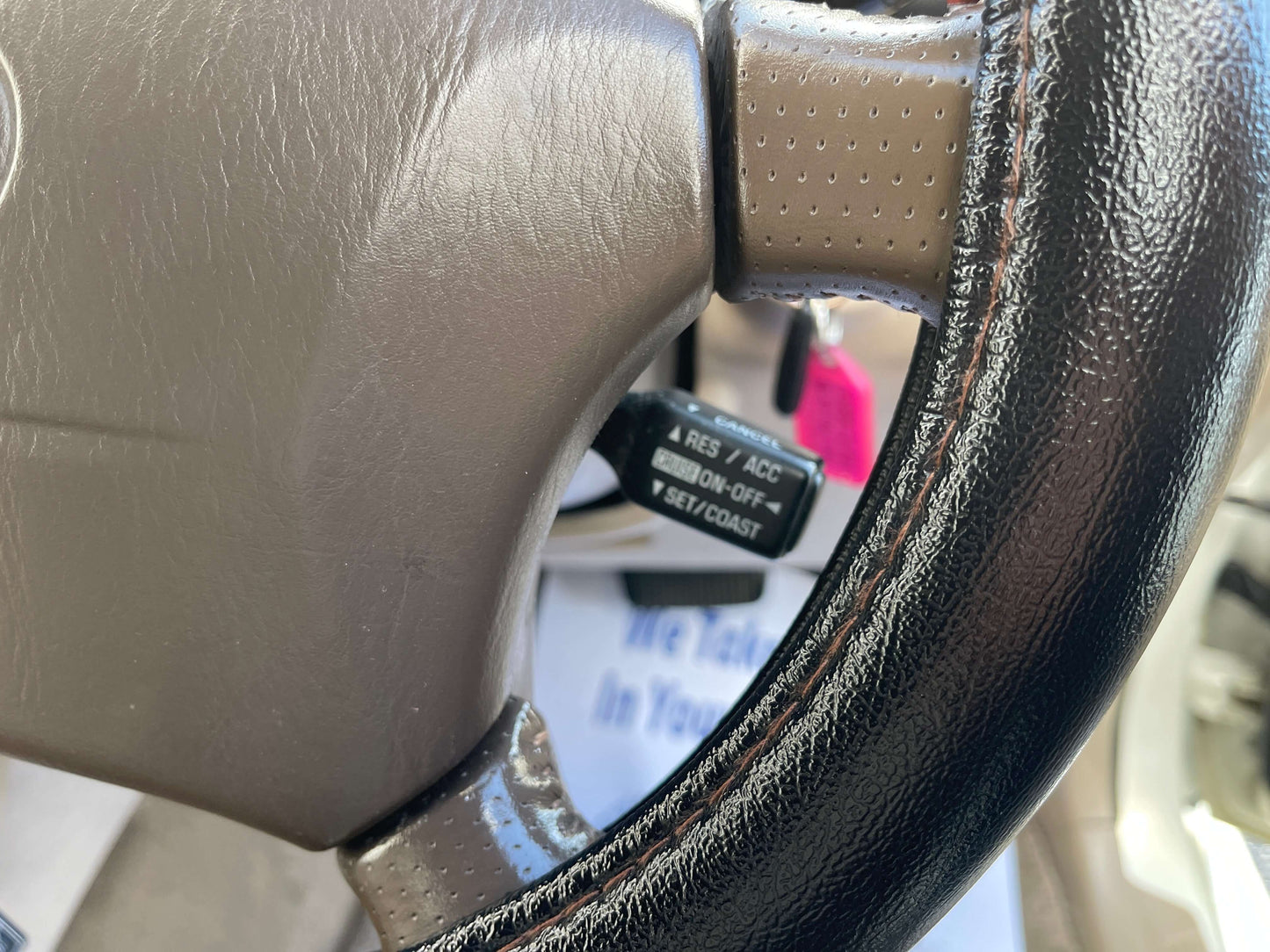 Close-up of the steering wheel controls for the 1998 Toyota Land Cruiser 100 VX Limited, featuring cruise control function.