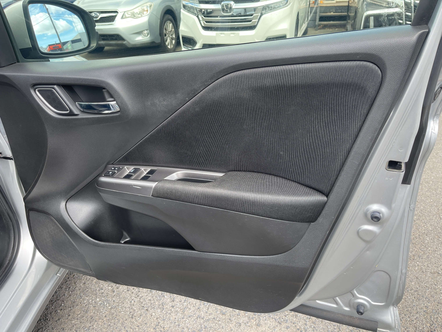 Interior view of the door panel of a 2015 Honda Grace 1.5 Hybrid EX, showcasing the sleek design and controls.