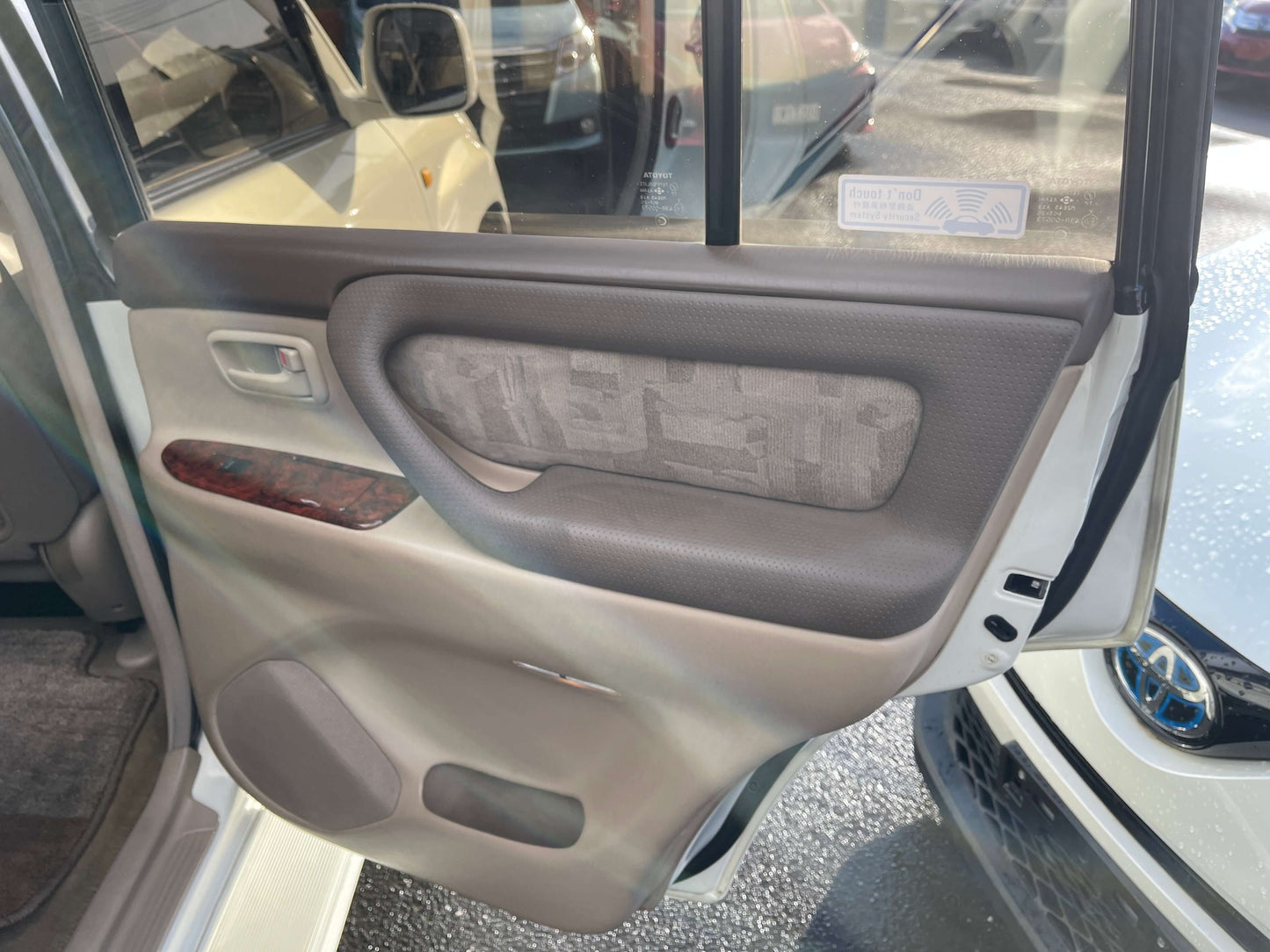Interior door panel of a 1998 Toyota Land Cruiser 100 VX Limited, showing premium materials and features.