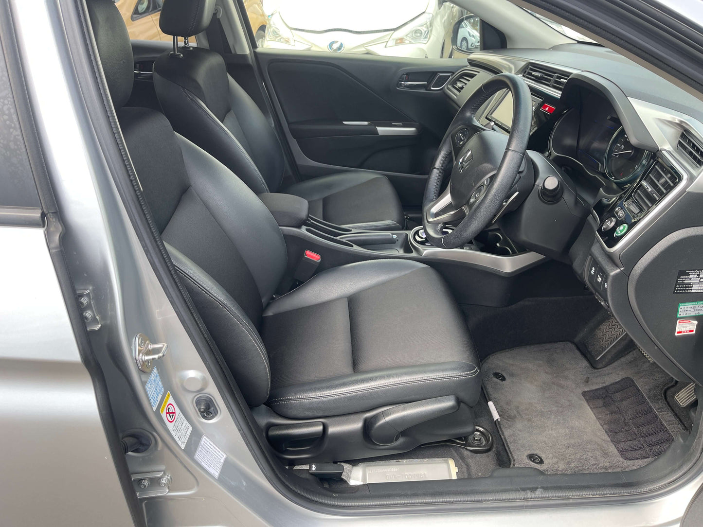 Interior view of a 2015 Honda Grace 1.5 Hybrid EX showcasing black seats and dashboard.
