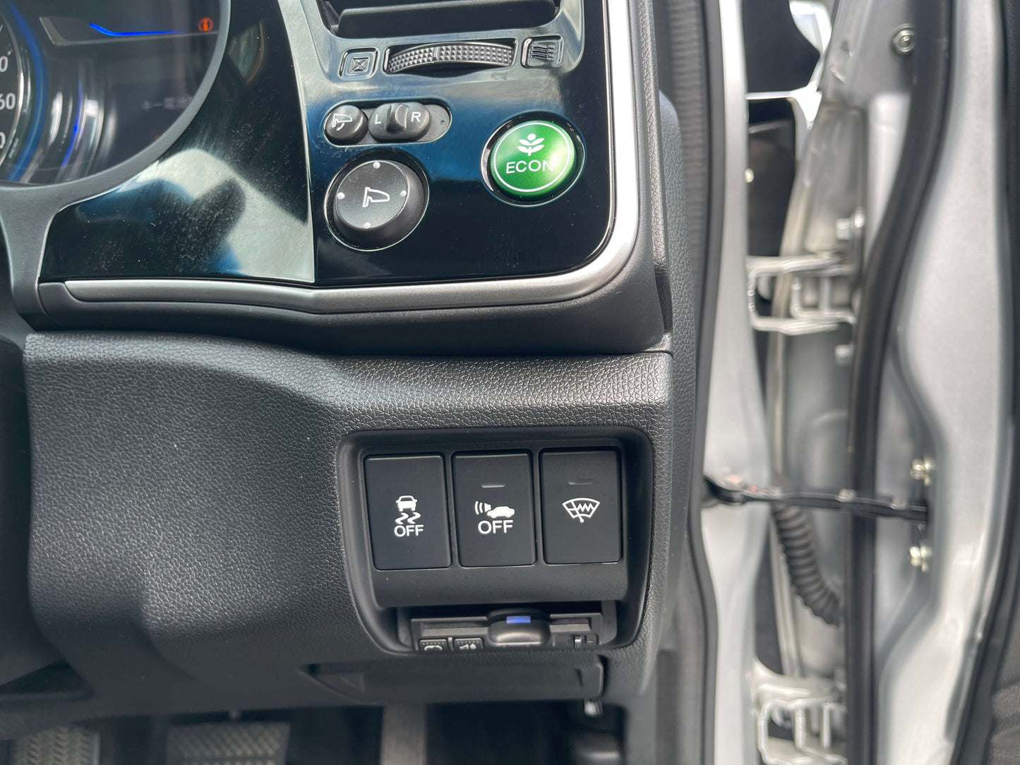 Dashboard controls of a 2015 Honda Grace 1.5 Hybrid, including ECON button and other function switches.