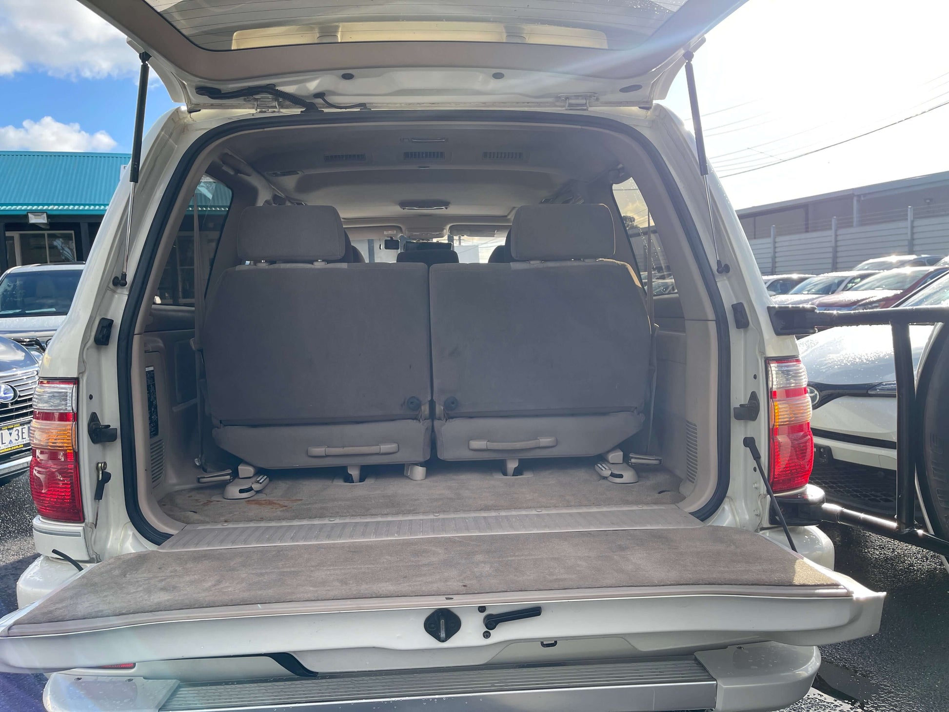Interior view of the cargo space in a 1998 Toyota Land Cruiser 100 VX Limited, featuring spacious seating and SUV design.