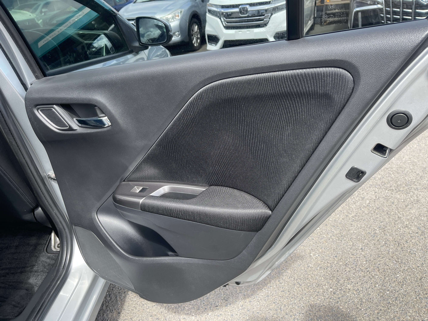 Interior view of 2015 Honda Grace 1.5 Hybrid driver door, showcasing sleek design and fabric accents.