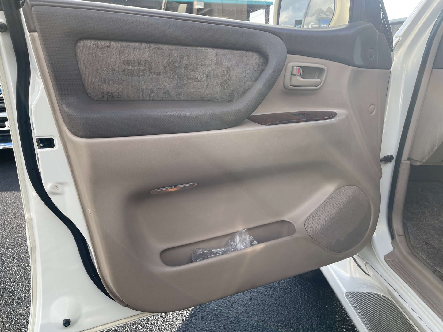 Interior view of the 1998 Toyota Land Cruiser 100 VX Limited door panel, showcasing premium finishes and features.