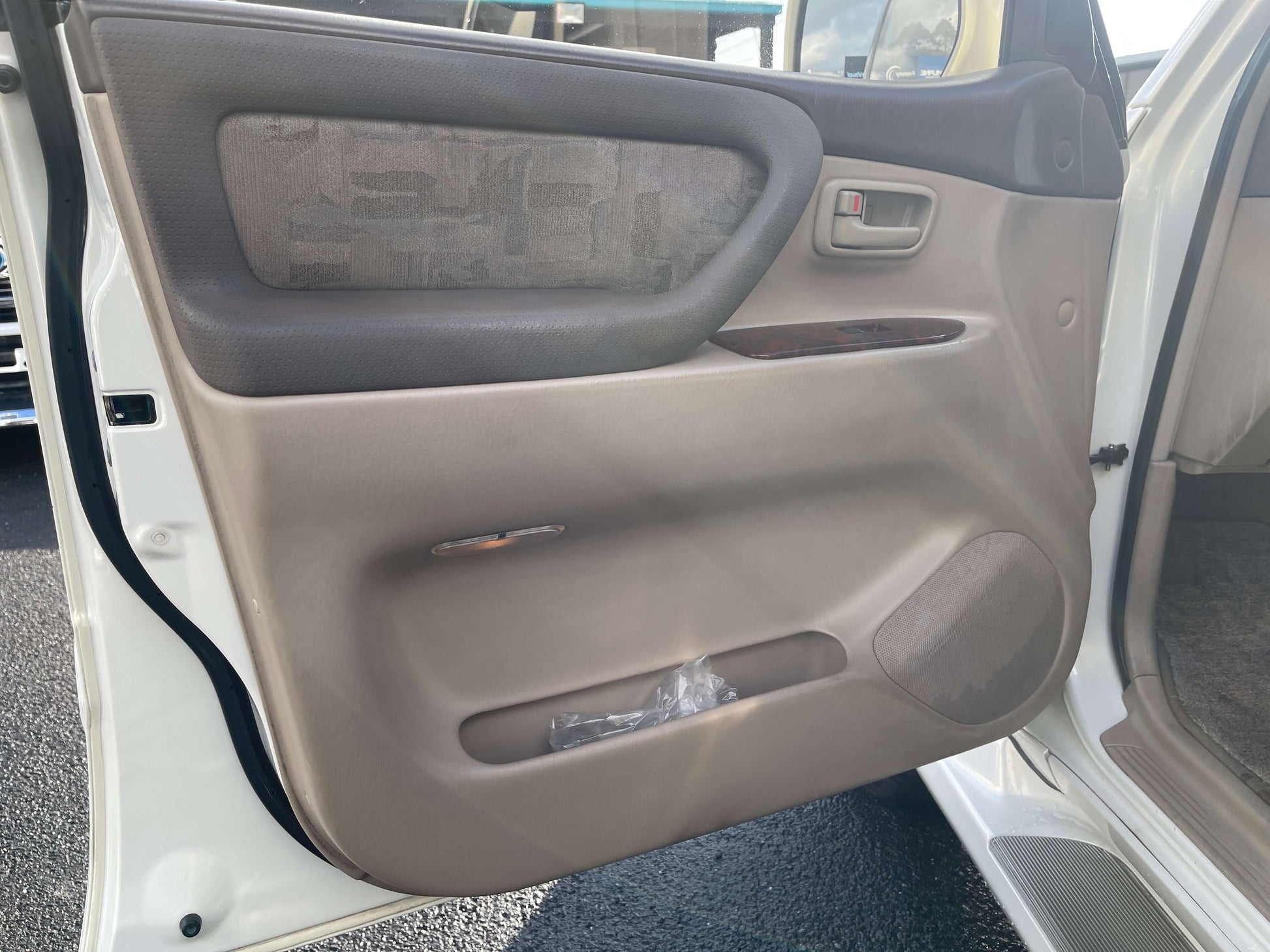 Interior view of the 1998 Toyota Land Cruiser 100 VX Limited door panel, showcasing premium finishes and features.