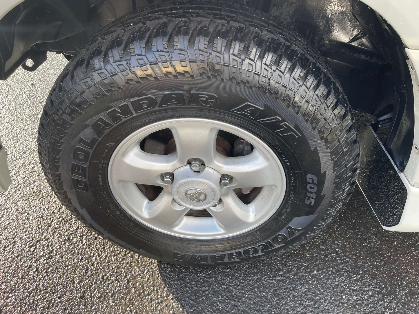 1998 Toyota Land Cruiser 100 VX Limited tire with Geolandar A/T tread design.