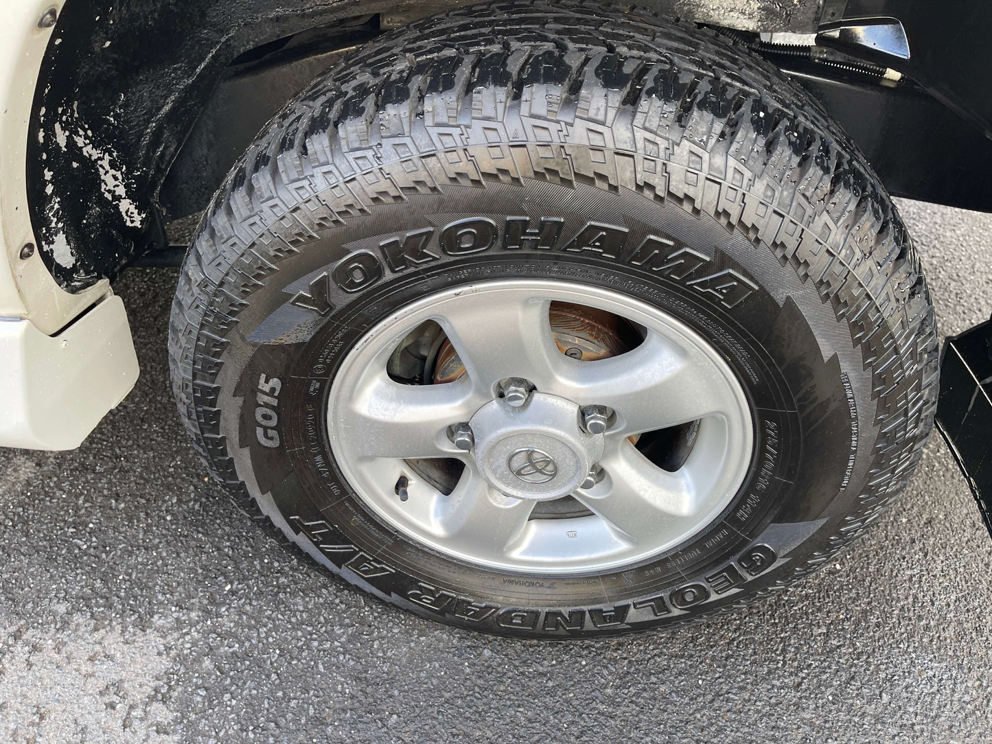 1998 Toyota Land Cruiser 100 VX Limited wheel and Yokohama Geolandar A/T tire close-up.