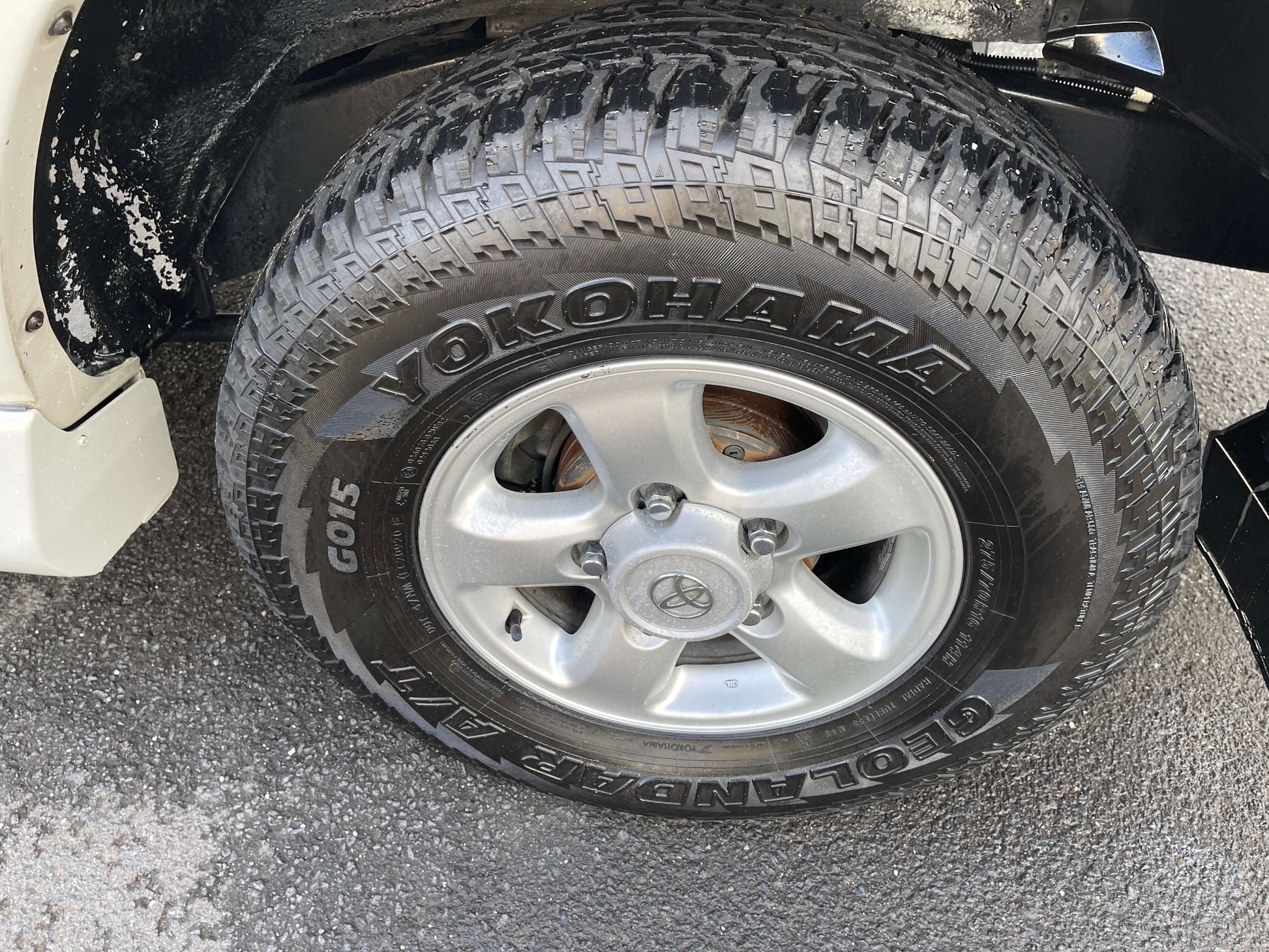 1998 Toyota Land Cruiser 100 VX Limited wheel and Yokohama Geolandar A/T tire close-up.