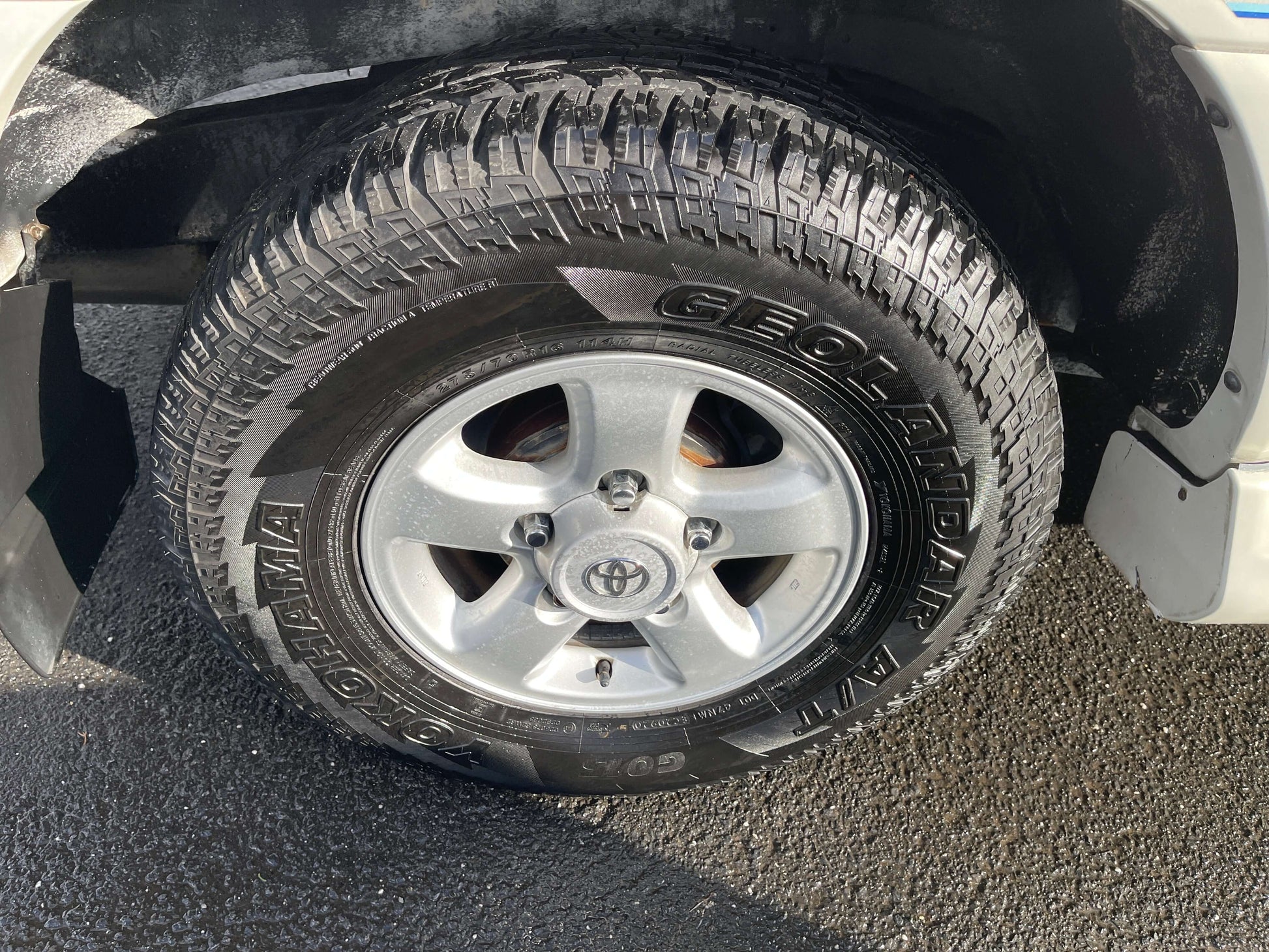 Close-up of the tire and alloy rim of a 1998 Toyota Land Cruiser 100 VX Limited, showcasing its rugged performance.