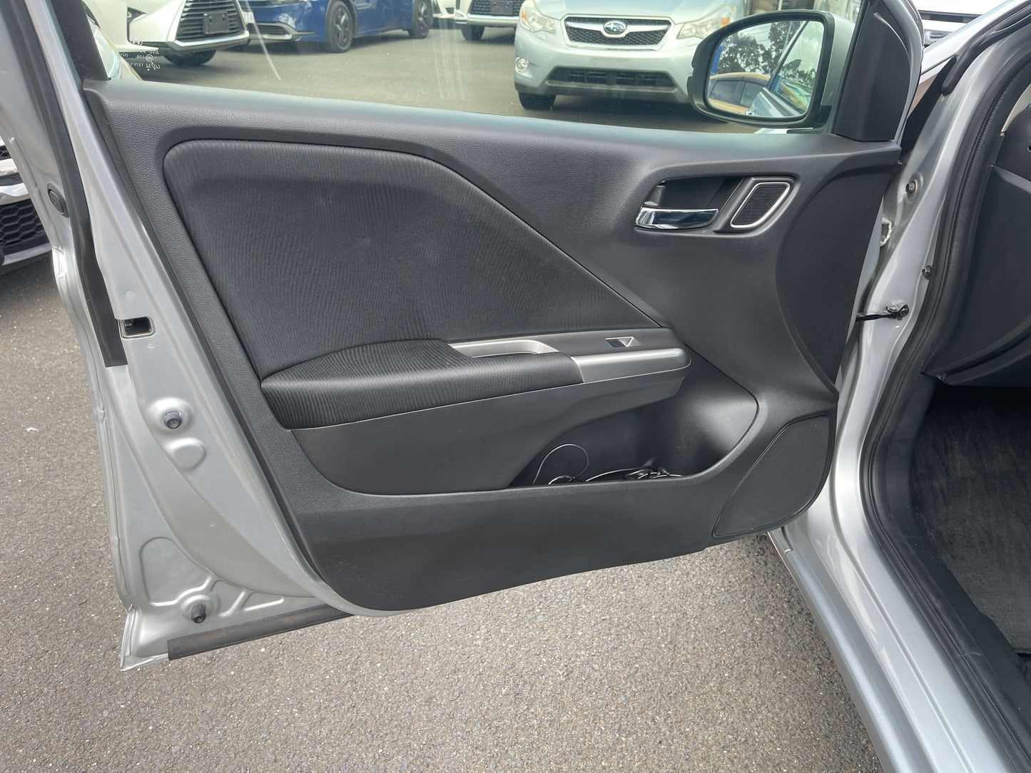 Interior view of the 2015 Honda Grace 1.5 Hybrid EX front door panel, showcasing design and features.