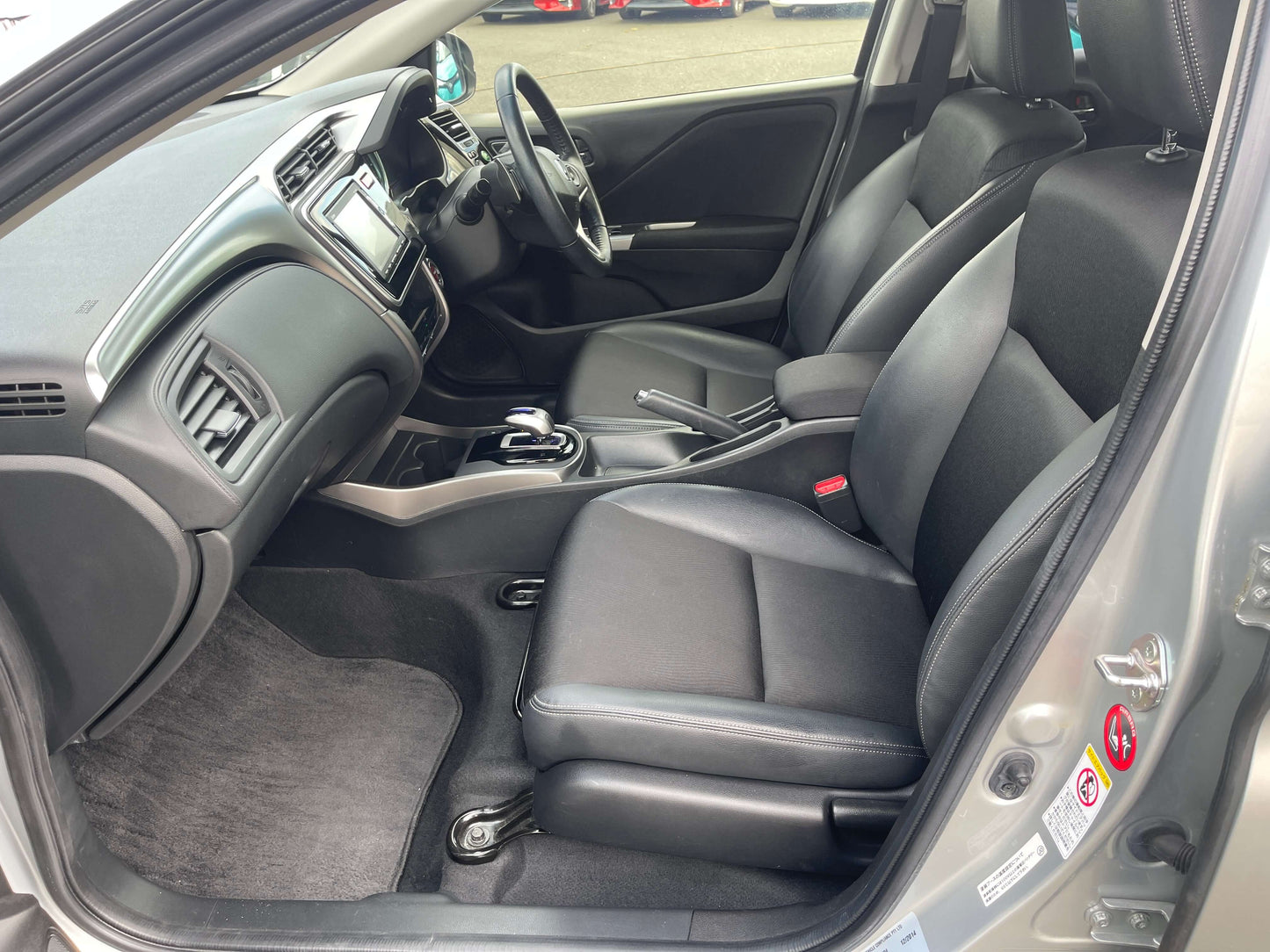 Interior view of a 2015 Honda Grace 1.5 Hybrid EX 5 seater, showcasing black seats and modern dashboard design.