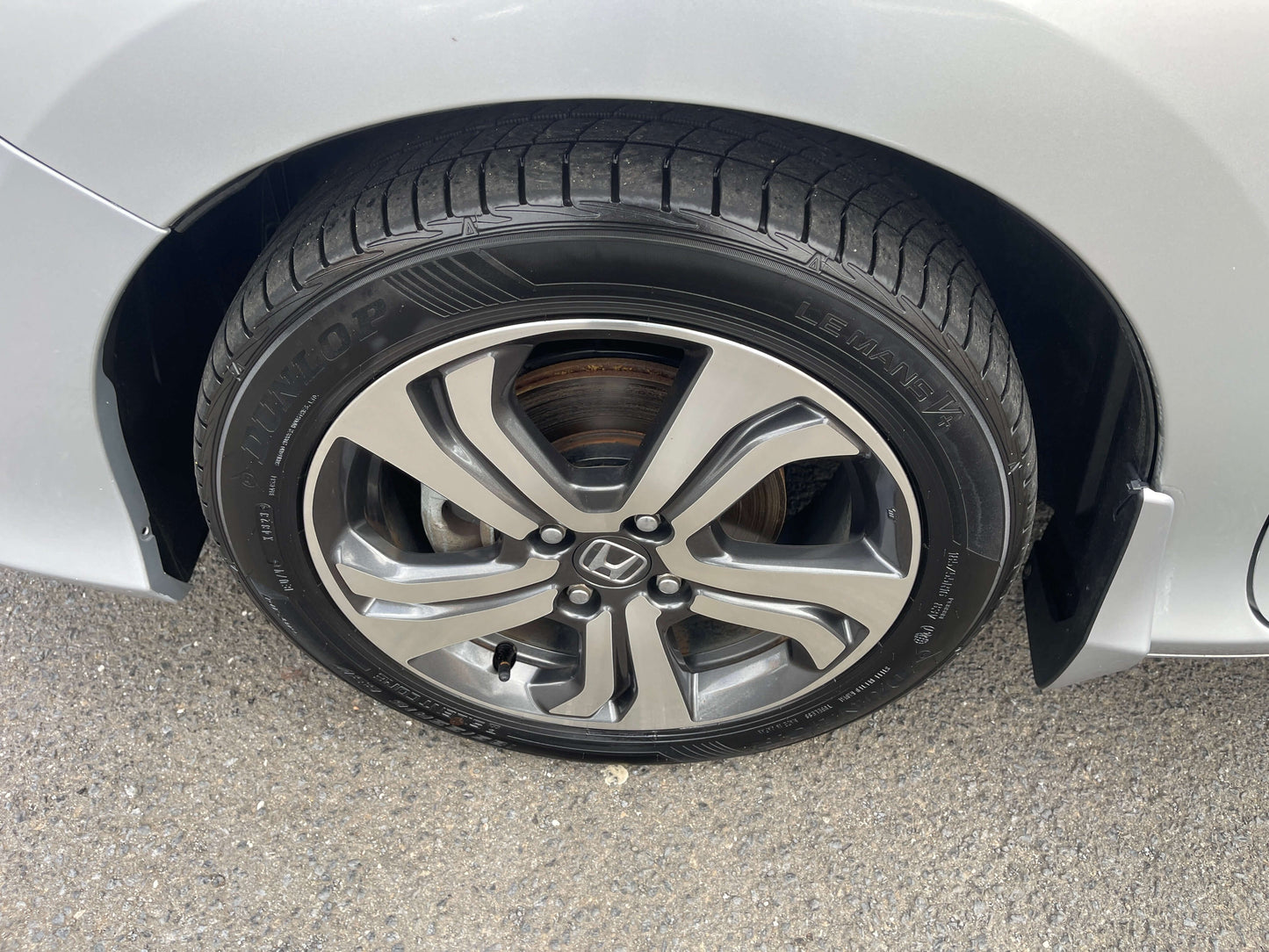 Close-up of the wheel of a 2015 Honda Grace 1.5 Hybrid showcasing alloy design and tire tread.