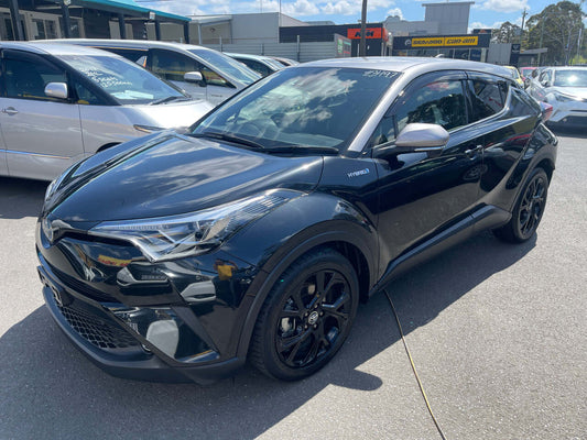 2019 Toyota C-HR 1.8L Hybrid luxury SUV in black parked outdoors, showcasing its sleek design and modern features.