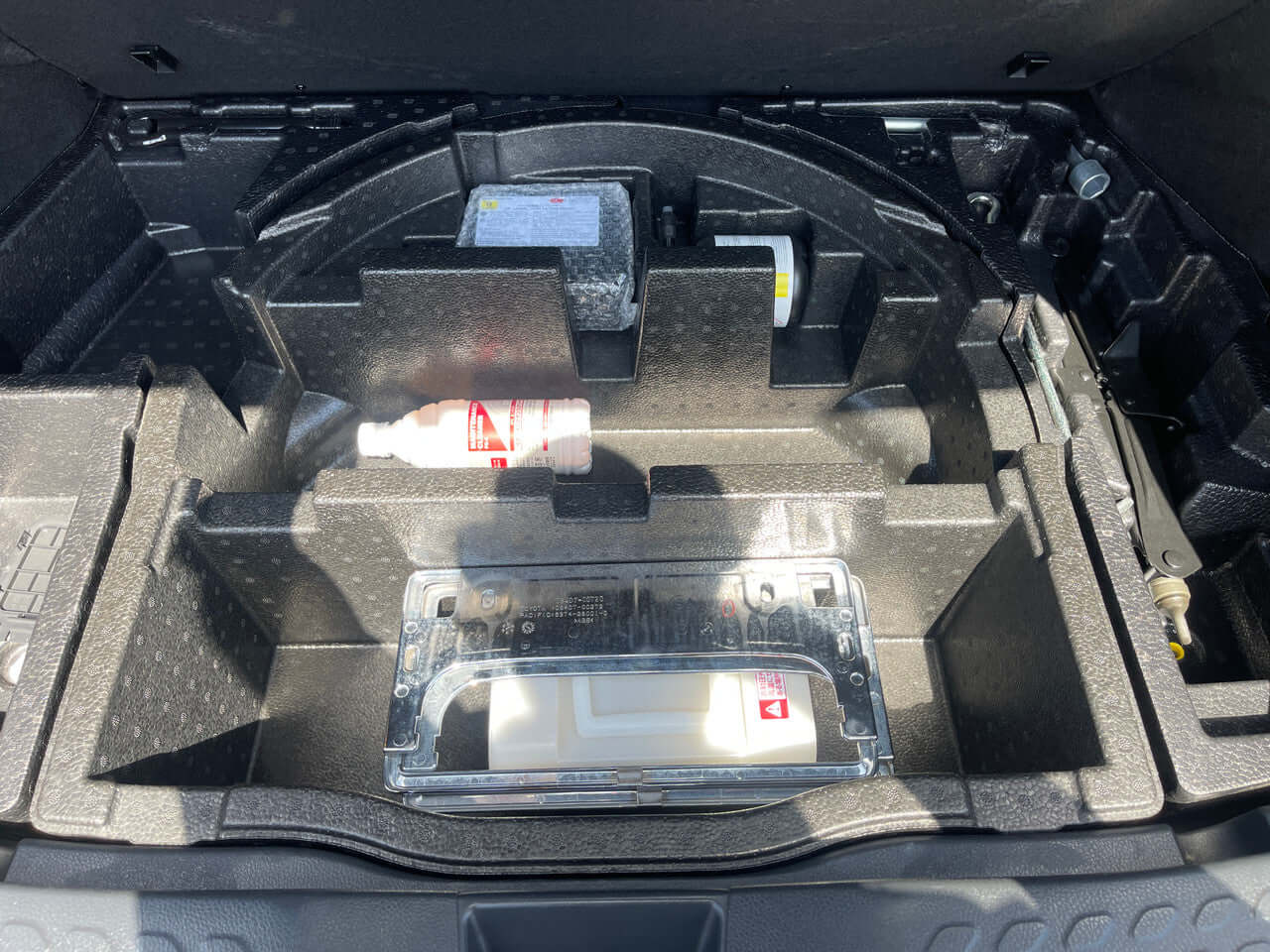 Storage area of the 2019 Toyota C-HR 1.8L Hybrid showcasing compartments and accessories.