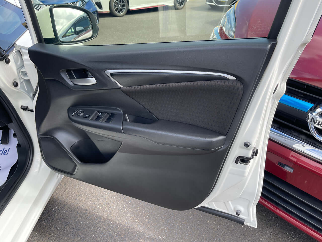 Interior view of the 2017 Honda Fit 1.5L Hybrid door panel showing controls and design features.