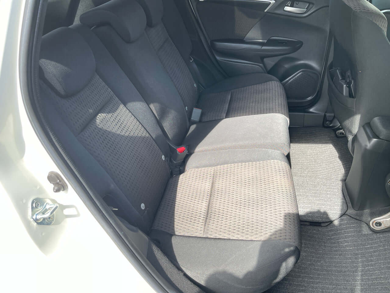 Interior view of the back seat of a 2017 Honda Fit 1.5L Hybrid, showcasing spacious seating for five passengers.