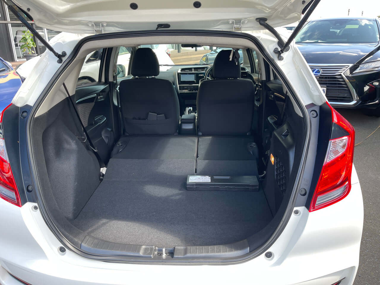 Interior view of the 2017 Honda Fit 1.5L Hybrid with spacious cargo area, showcasing rear seats folded down.
