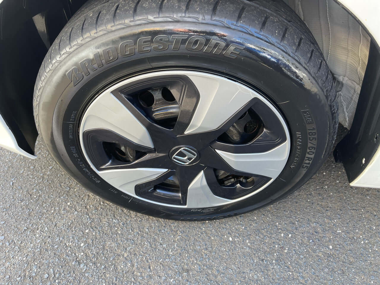 Close-up view of the black and silver alloy wheel and Bridgestone tire on a 2017 Honda Fit 1.5L Hybrid.