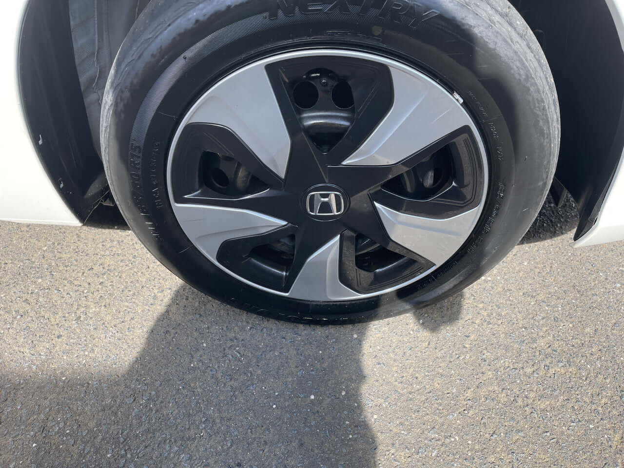 2017 Honda Fit 1.5L Hybrid wheel with modern alloy design and tire on pavement.