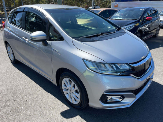 2018 Honda Fit 1.5 Hybrid L Honda Sensing in silver, parked with a clear view of its stylish design and hybrid features.