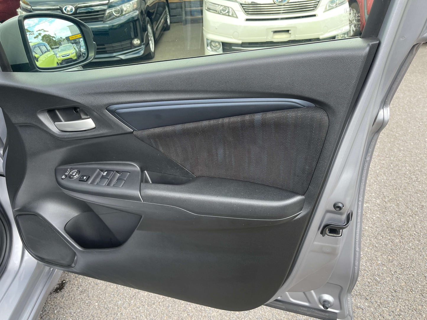 Interior view of 2019 Honda Shuttle 1.5L 4WD Hybrid door panel with controls and fabric trim.