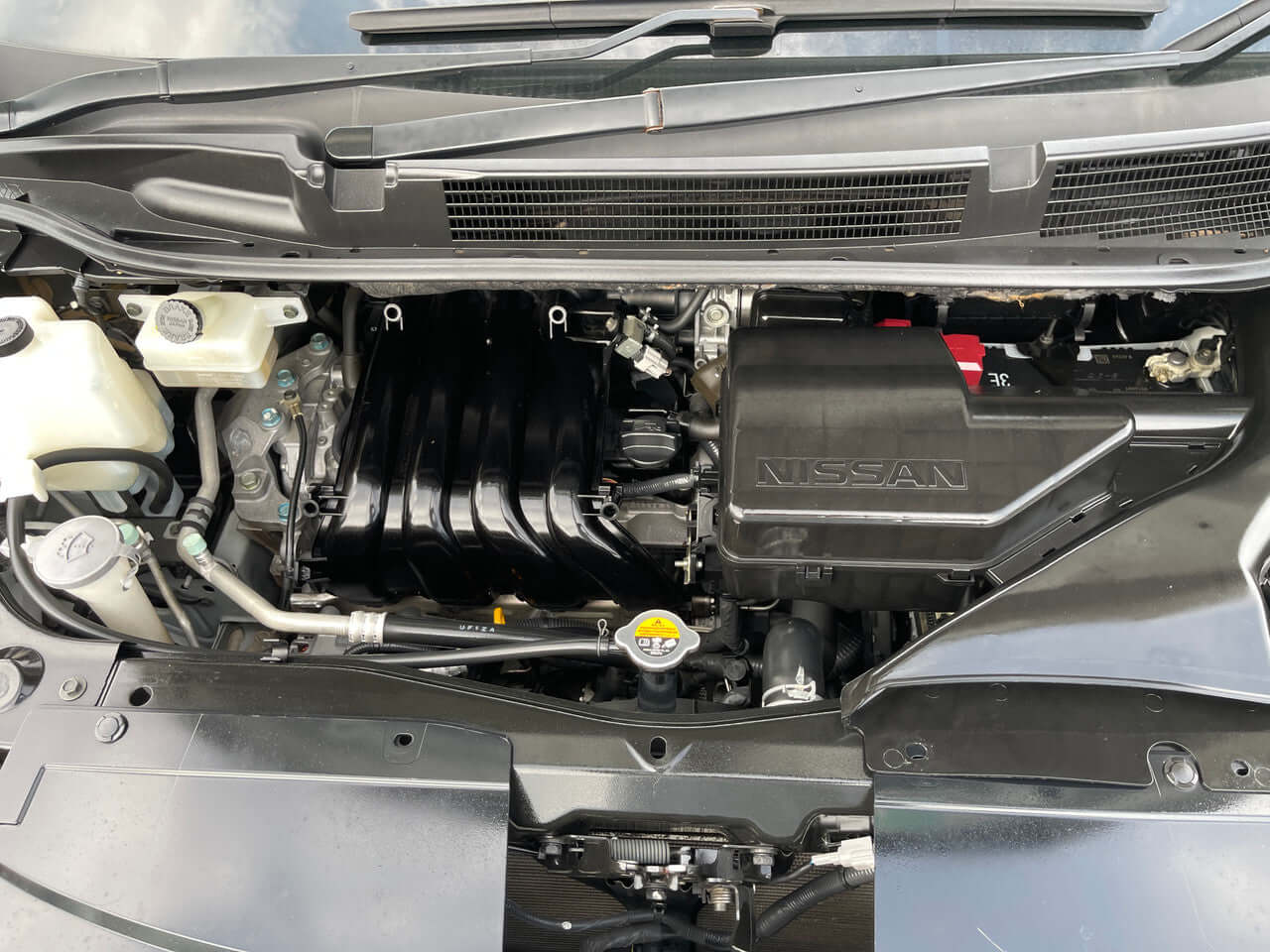 Engine compartment of a 2014 Nissan Serena 2.0L S-Hybrid Rider showcasing its efficient power system.